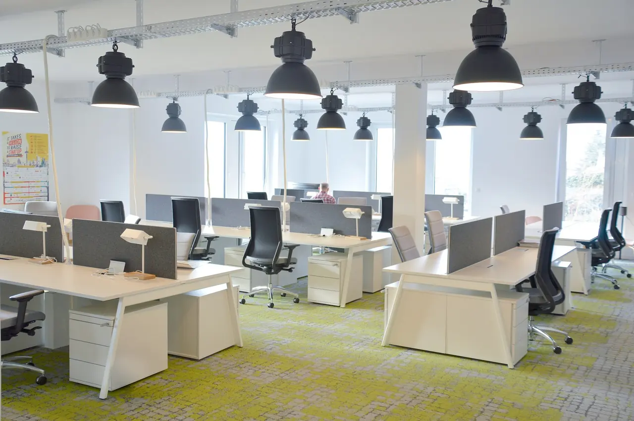 Offenes Büro mit Arbeitsplätzen, Trennwänden und Pendelleuchten