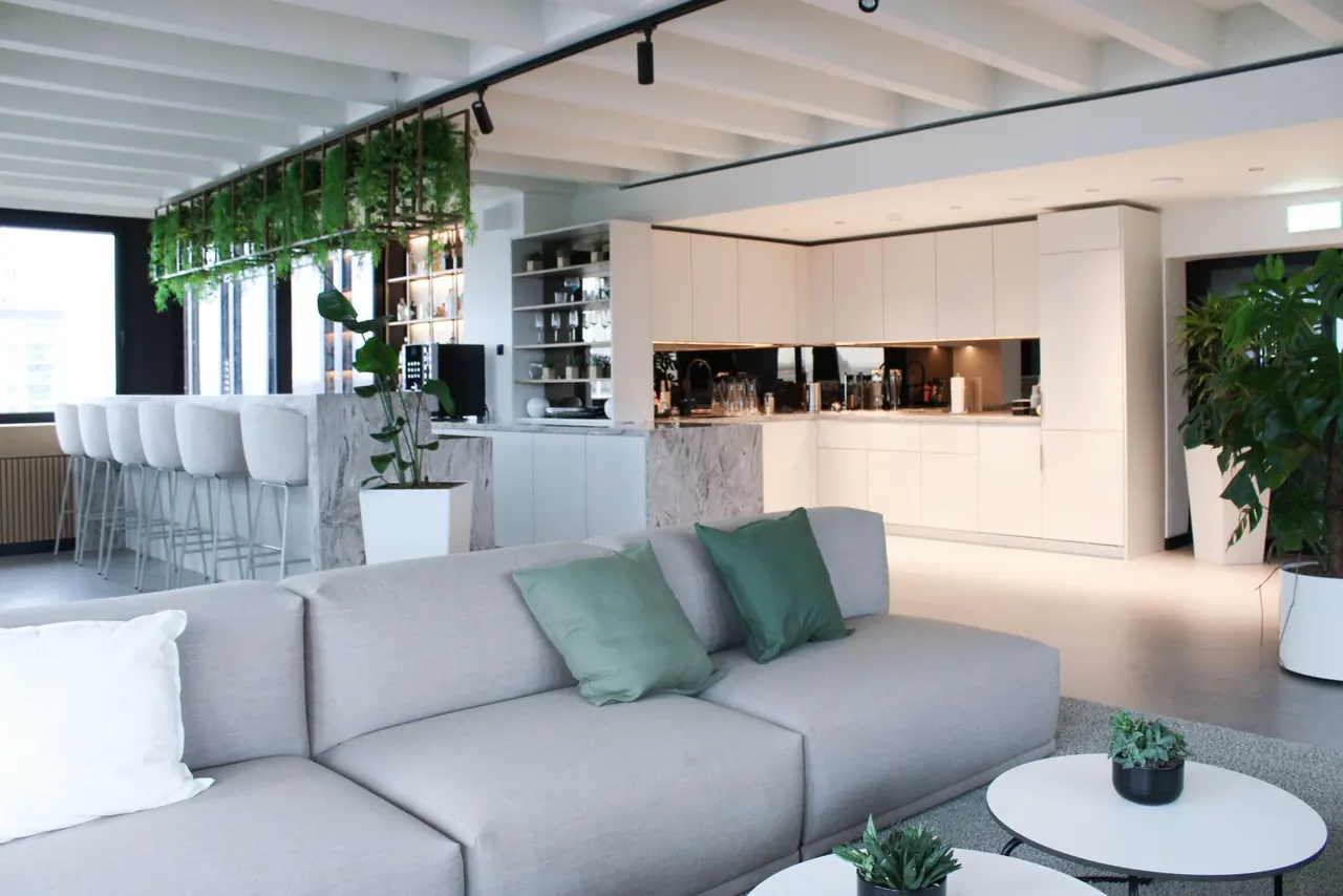 Offene Büroküche mit Sofa-Lounge und Pflanzen